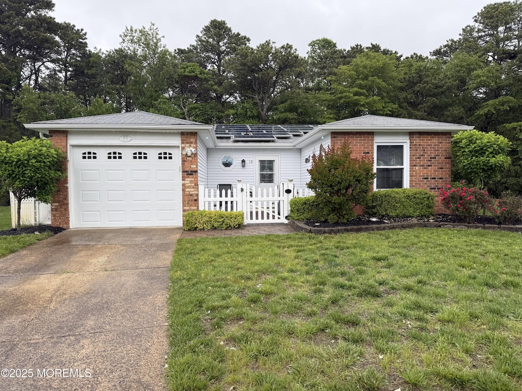 15 Tudor Ct, Brick, NJ 08723 - view of front facade featuring brick siding, a garage, driveway, and view of wooded area