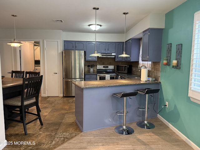 15 Tudor Ct, Brick, NJ 08723 - kitchen featuring appliances with stainless steel finishes, a peninsula, backsplash, blue cabinets, and under cabinet range hood
