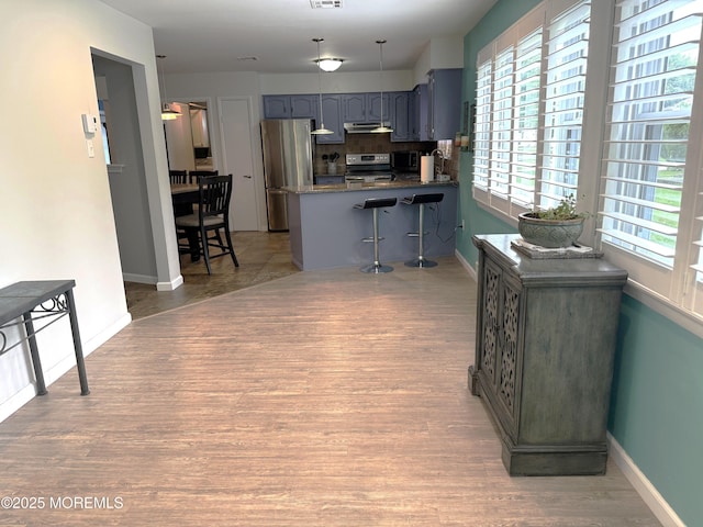 15 Tudor Ct, Brick, NJ 08723 - kitchen with stainless steel appliances, under cabinet range hood, a peninsula, tasteful backsplash, and light wood-style floors