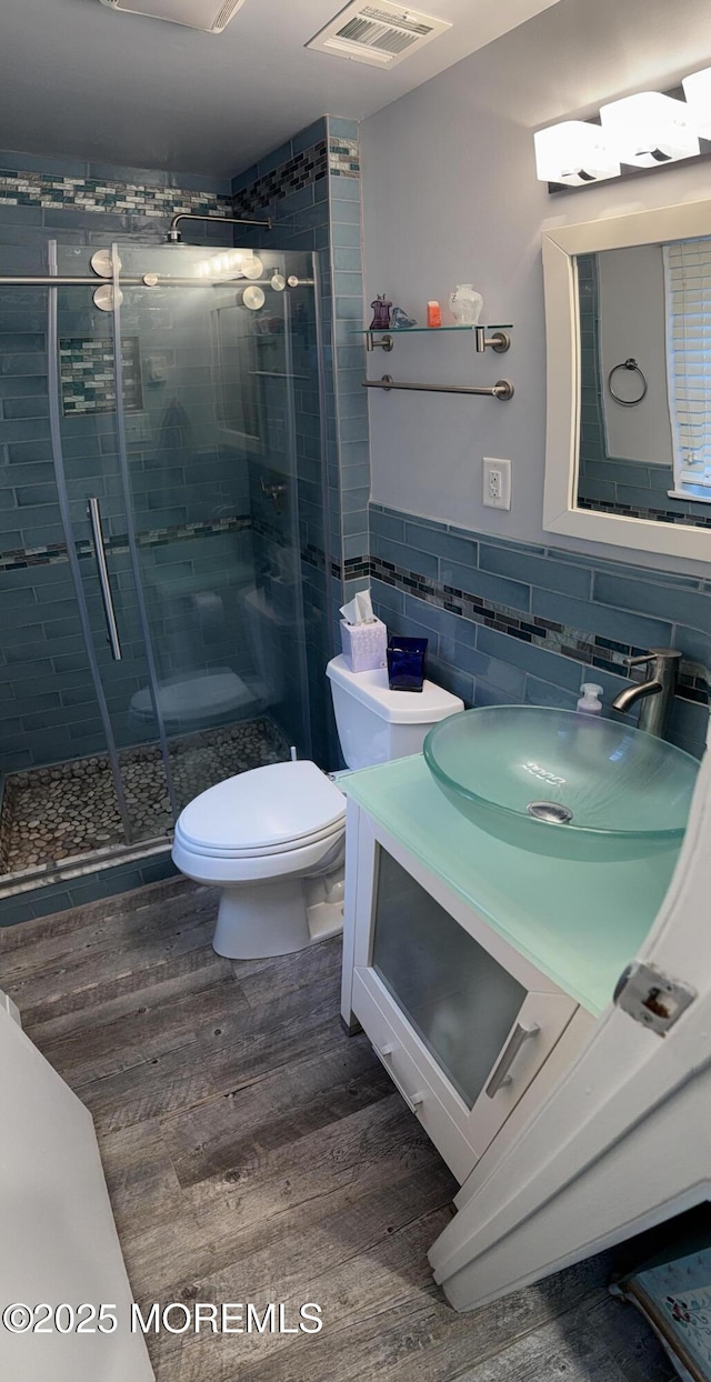 15 Tudor Ct, Brick, NJ 08723 - bathroom with tile walls, toilet, wood finished floors, vanity, and a stall shower
