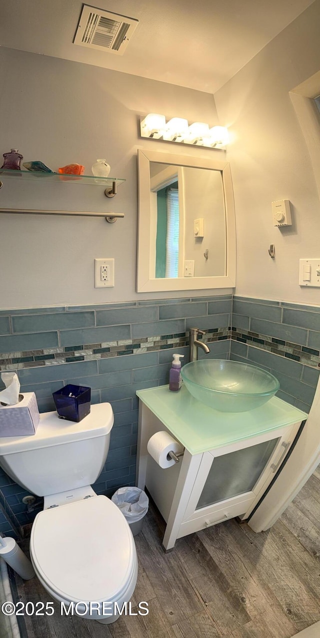 15 Tudor Ct, Brick, NJ 08723 - bathroom with tile walls, wood finished floors, vanity, toilet, and a wainscoted wall