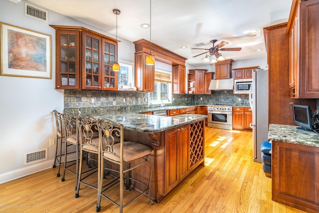 834 Leeward Dr, Forked River, NJ 08731 - kitchen with stainless steel appliances, a peninsula, light wood-style flooring, a ceiling fan, and tasteful backsplash