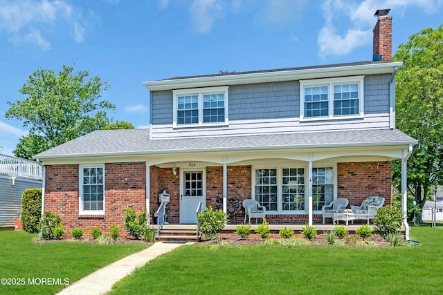 604 N Blvd, Lake Como, NJ 07719 - view of front facade with a chimney, a front yard, covered porch, and brick siding