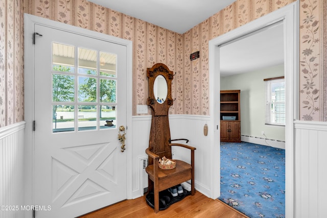 604 N Blvd, Lake Como, NJ 07719 - doorway to outside with a baseboard heating unit, a wainscoted wall, wallpapered walls, and wood finished floors