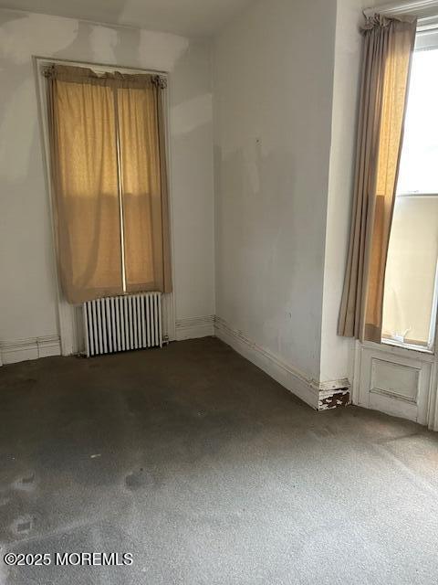 62 Washington St, Red Bank, NJ 07701 - carpeted empty room with radiator heating unit and baseboards