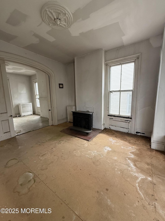62 Washington St, Red Bank, NJ 07701 - unfurnished living room with radiator, a wood stove, plenty of natural light, and arched walkways