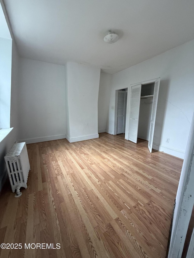 62 Washington St, Red Bank, NJ 07701 - unfurnished bedroom with light wood finished floors, two closets, radiator heating unit, and baseboards