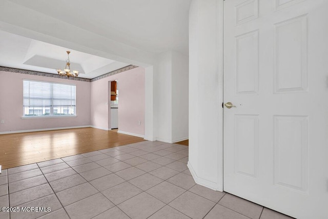 3167 Wood Spring Ln, Toms River, NJ 08755 - empty room featuring light tile patterned flooring, a chandelier, baseboards, and a tray ceiling