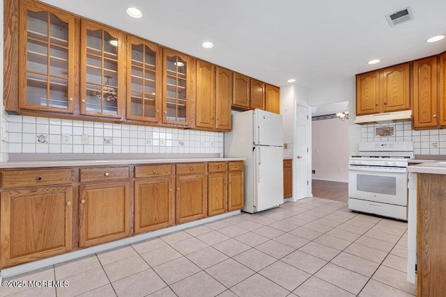3167 Wood Spring Ln, Toms River, NJ 08755 - kitchen with white appliances, recessed lighting, brown cabinets, light countertops, and backsplash
