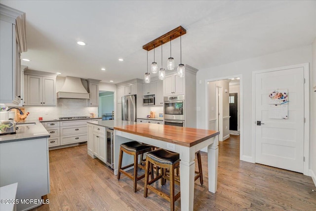 18 Vaughn Dr, Middletown, NJ 07748 - kitchen featuring stainless steel appliances, custom range hood, a sink, a kitchen island, and wood finished floors