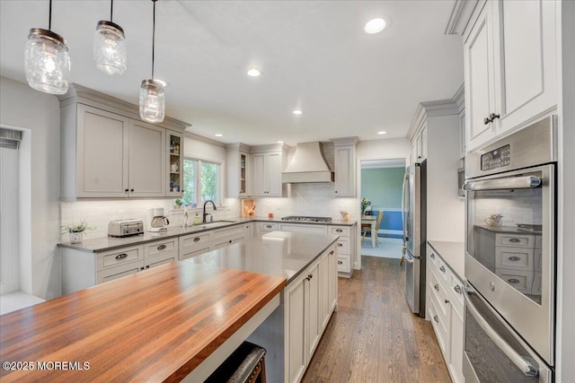 18 Vaughn Dr, Middletown, NJ 07748 - kitchen featuring wooden counters, appliances with stainless steel finishes, custom exhaust hood, backsplash, and wood finished floors