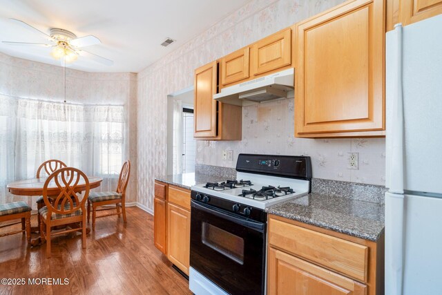 73 Summerhill Dr, Manahawkin, NJ 08050 - kitchen with freestanding refrigerator, gas range, under cabinet range hood, a ceiling fan, and wood finished floors