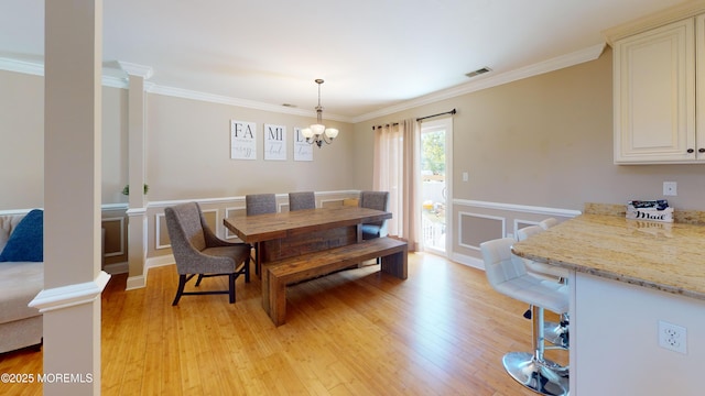 545 Hopedale Dr SW, Berkeley, NJ 08721 - dining room featuring light wood-style floors, a chandelier, crown molding, ornate columns, and wainscoting