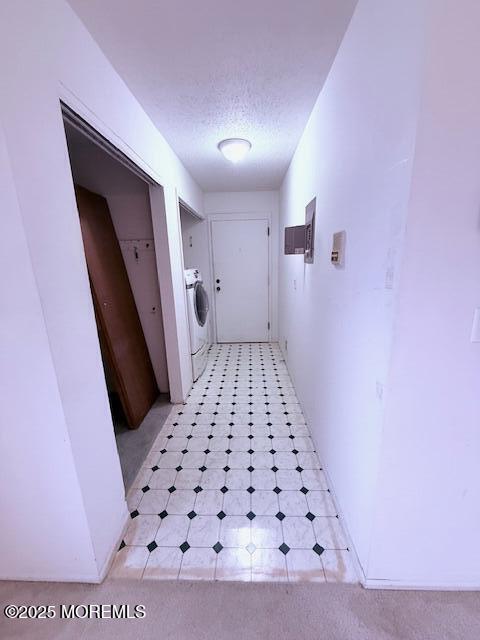 98 Beachway Ave Unit 9, Keansburg, NJ 07734 - hallway with washer / dryer, a textured ceiling, and light flooring