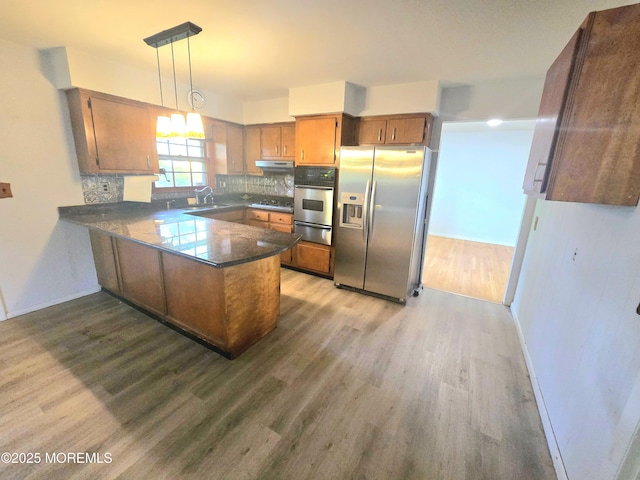 1305 Squirrel Rd, Wall, NJ 07719 - kitchen featuring stainless steel appliances, a warming drawer, wood finished floors, a peninsula, and brown cabinets