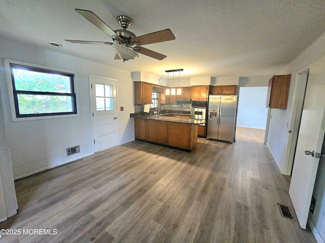 1305 Squirrel Rd, Wall, NJ 07719 - kitchen featuring stainless steel appliances, a peninsula, brown cabinets, a sink, and wood finished floors