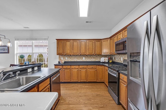 27 Cromwell Ln, Jackson, NJ 08527 - kitchen featuring stainless steel appliances, a sink, dark countertops, and brown cabinets