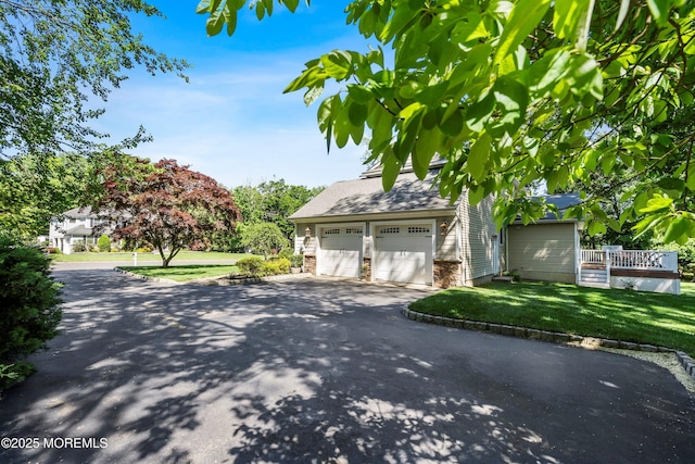10 Woods Rd, West Long Branch, NJ 07764 - view of front of home featuring a front lawn, asphalt driveway, and a garage