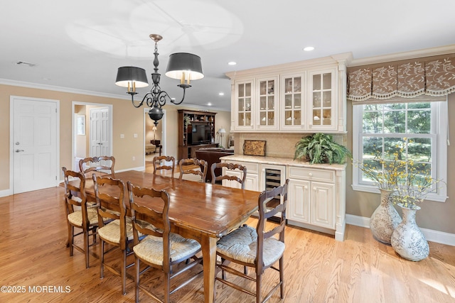 10 Woods Rd, West Long Branch, NJ 07764 - dining room with ornamental molding, baseboards, light wood-style floors, wine cooler, and a chandelier