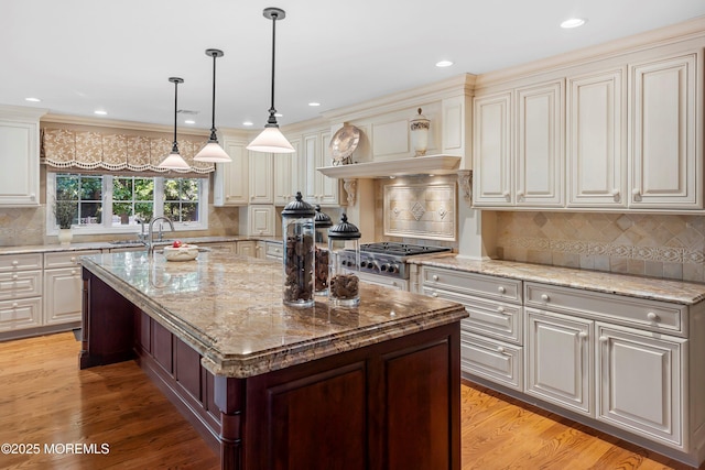10 Woods Rd, West Long Branch, NJ 07764 - kitchen featuring a center island with sink, light stone countertops, decorative backsplash, decorative light fixtures, and recessed lighting