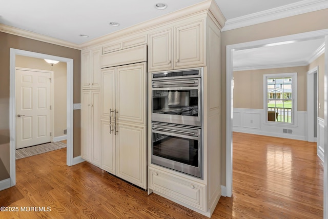 10 Woods Rd, West Long Branch, NJ 07764 - kitchen with stainless steel double oven, light wood-style flooring, ornamental molding, and cream cabinets