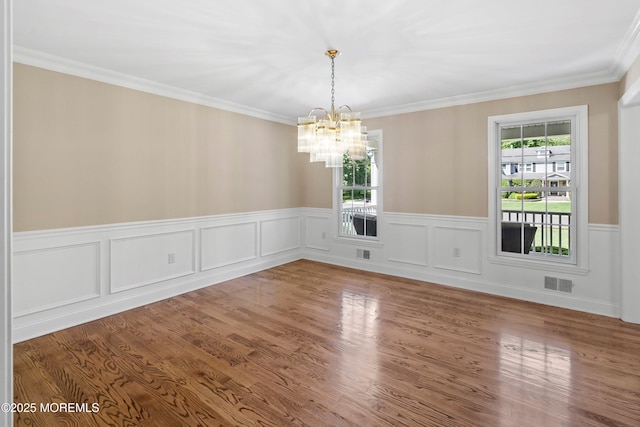 10 Woods Rd, West Long Branch, NJ 07764 - spare room featuring a chandelier, wainscoting, ornamental molding, and wood finished floors