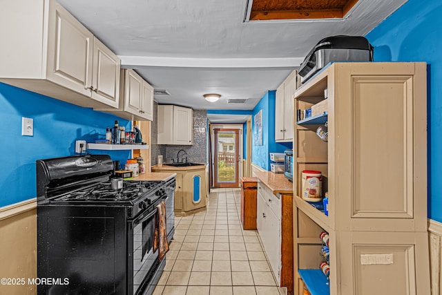 12 Central Ave, Waretown, NJ 08758 - kitchen featuring gas stove, a sink, light tile patterned floors, white cabinets, and light countertops