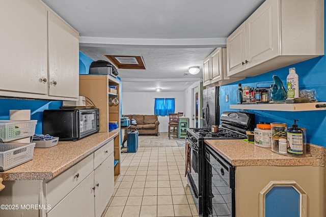 12 Central Ave, Waretown, NJ 08758 - kitchen featuring black appliances, light tile patterned flooring, light countertops, and white cabinetry