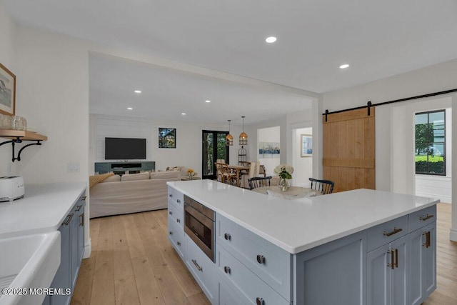2110 Edgewood Pl, Spring Lake, NJ 07762 - kitchen with stainless steel microwave, a kitchen island, light wood-style flooring, light countertops, and recessed lighting