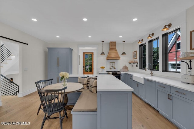 2110 Edgewood Pl, Spring Lake, NJ 07762 - kitchen featuring a sink, gray cabinets, custom exhaust hood, light countertops, and a center island