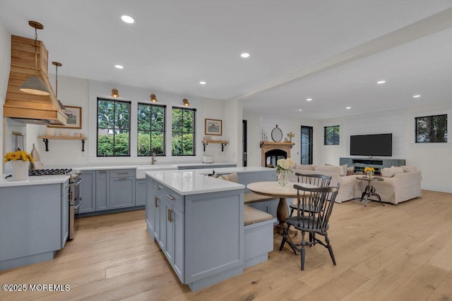 2110 Edgewood Pl, Spring Lake, NJ 07762 - kitchen with stainless steel stove, gray cabinets, light countertops, a sink, and a kitchen island