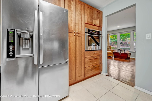 66 Cold Indian Springs Rd, Ocean Twp, NJ 07712 - kitchen featuring stainless steel appliances, light tile patterned floors, baseboards, and brown cabinets