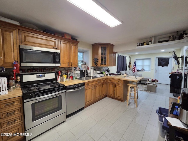 37 Beachway Ave, Keansburg, NJ 07734 - kitchen with stainless steel appliances, a peninsula, open floor plan, brown cabinets, and a sink