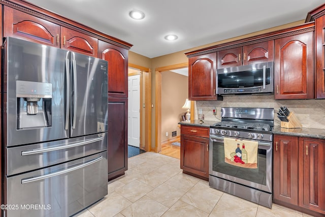 1 River Dr, Farmingdale, NJ 07727 - kitchen with stainless steel appliances, tasteful backsplash, dark stone countertops, reddish brown cabinets, and recessed lighting