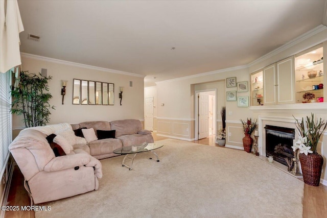 634 Saint Andrews Pl, Manalapan, NJ 07726 - living room with crown molding, a wainscoted wall, a fireplace with flush hearth, and a decorative wall
