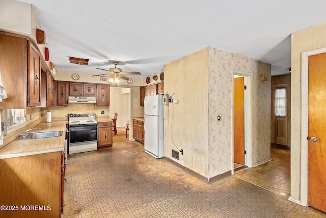 1233 Herkimer Rd, Brick, NJ 08724 - kitchen with white appliances, under cabinet range hood, a sink, light countertops, and brown cabinets