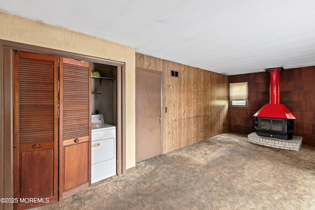 1233 Herkimer Rd, Brick, NJ 08724 - unfurnished living room with washer / clothes dryer, a wood stove, carpet flooring, and wooden walls