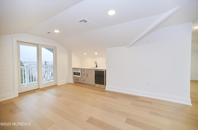 674 Lake Ave, Bay Head, NJ 08742 - unfurnished living room featuring vaulted ceiling, light wood-style floors, wine cooler, baseboards, and a sink