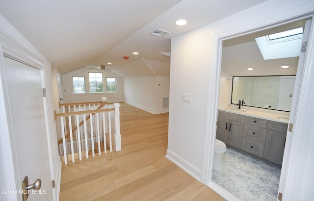 674 Lake Ave, Bay Head, NJ 08742 - corridor featuring an upstairs landing, a skylight, a sink, light wood-type flooring, and baseboards