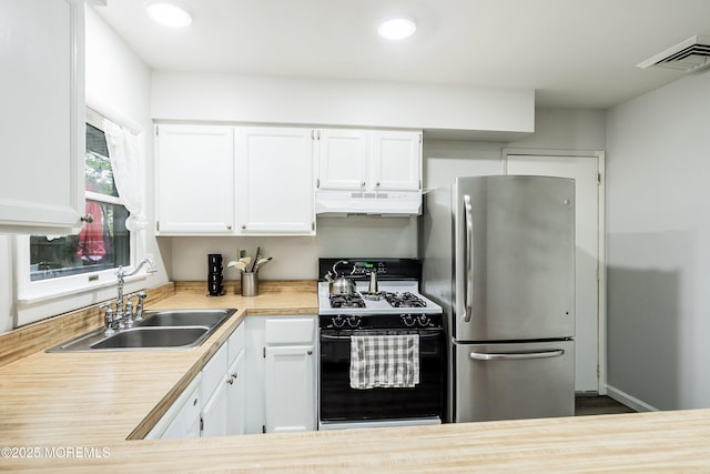 1015 Barnacle Dr, Manahawkin, NJ 08050 - kitchen featuring black gas stove, freestanding refrigerator, under cabinet range hood, a sink, and light countertops