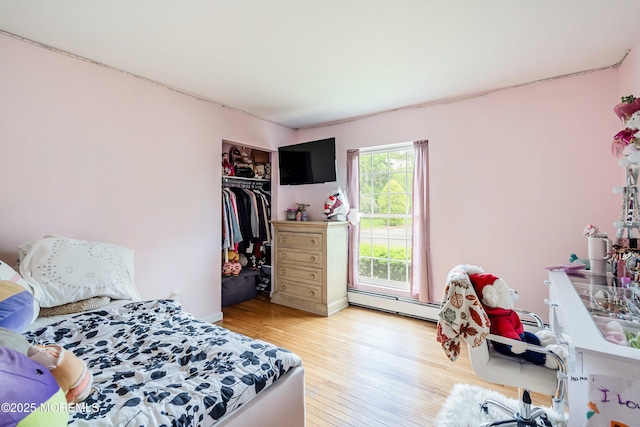 1015 Barnacle Dr, Manahawkin, NJ 08050 - bedroom featuring a baseboard heating unit, light wood-type flooring, a closet, and baseboard heating