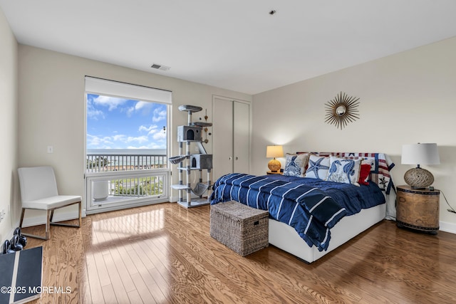 432 Ocean Blvd N Unit 506, Long Branch, NJ 07740 - bedroom featuring access to outside, wood finished floors, a water view, and baseboards