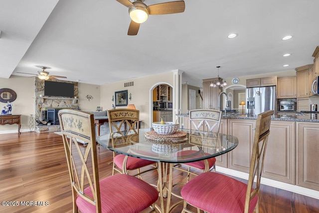 221 Bay Stream Dr, Toms River, NJ 08753 - dining room with a ceiling fan, a fireplace, wood finished floors, recessed lighting, and arched walkways