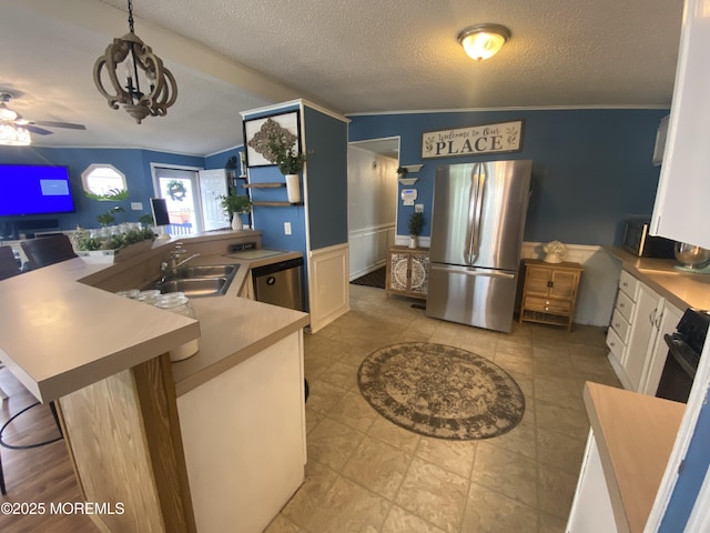89 Seattle Slew Dr, Howell, NJ 07731 - kitchen with appliances with stainless steel finishes, a sink, a textured ceiling, white cabinets, and wainscoting