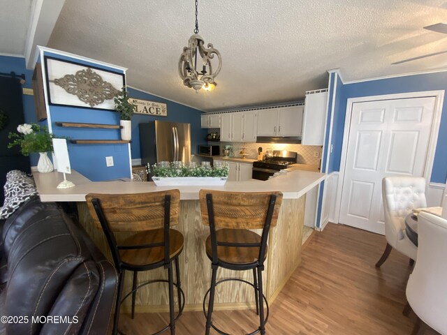 89 Seattle Slew Dr, Howell, NJ 07731 - kitchen with stainless steel appliances, a peninsula, light countertops, white cabinetry, and a textured ceiling