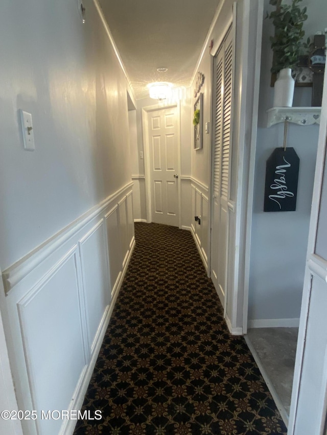 89 Seattle Slew Dr, Howell, NJ 07731 - hallway featuring a decorative wall and a wainscoted wall