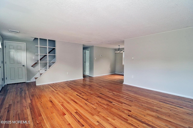 122 Oakwood Pl, Forked River, NJ 08731 - unfurnished room featuring a chandelier, hardwood / wood-style floors, stairs, a textured ceiling, and baseboards