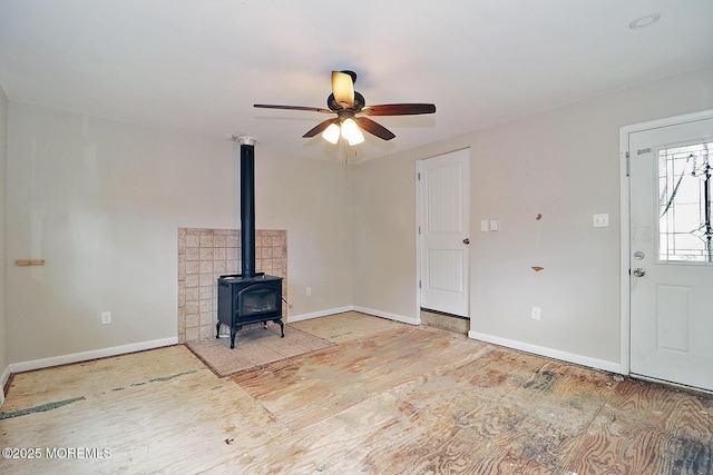 122 Oakwood Pl, Forked River, NJ 08731 - unfurnished living room with a wood stove, baseboards, a ceiling fan, and wood finished floors