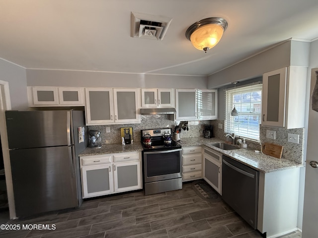 1134A Argyll Cir, Lakewood, NJ 08701 - kitchen featuring stainless steel appliances, under cabinet range hood, a sink, white cabinets, and tasteful backsplash
