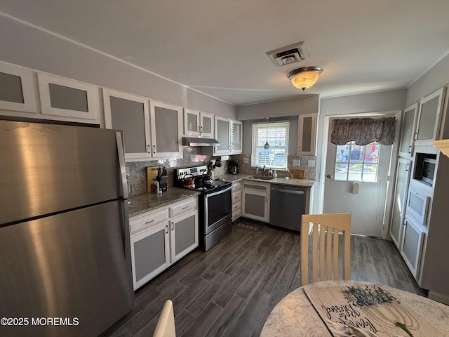 1134A Argyll Cir, Lakewood, NJ 08701 - kitchen featuring appliances with stainless steel finishes, light stone counters, a sink, decorative backsplash, and dark wood-type flooring